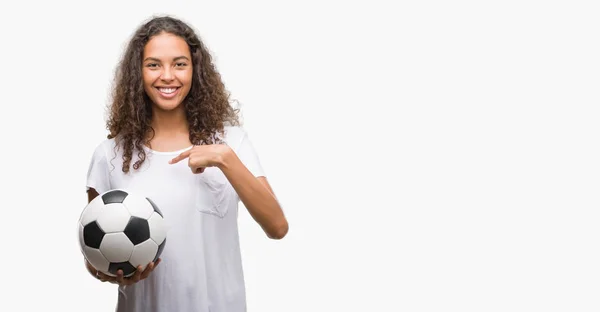 Joven Mujer Hispana Sosteniendo Pelota Fútbol Con Cara Sorpresa Apuntando —  Fotos de Stock