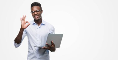 Parmak, mükemmel sembolü ile ok işareti yapıyor bilgisayar dizüstü kullanarak genç Afro-Amerikalı iş adamı