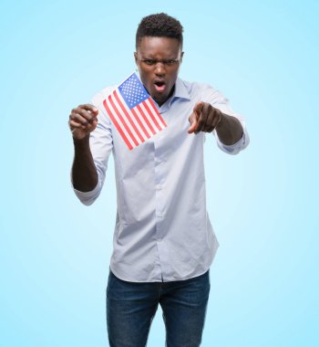 ABD bayrağı kamera ve size, el işareti, pozitif ve kendinden emin bir jest ön parmak ile işaret tutan genç Afro-Amerikan adam