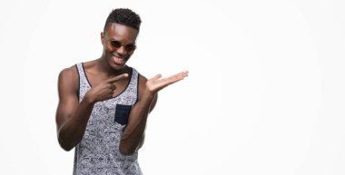 El ve parmak ile işaret çok mutlu güneş gözlüğü takmış genç Afro-Amerikan adam