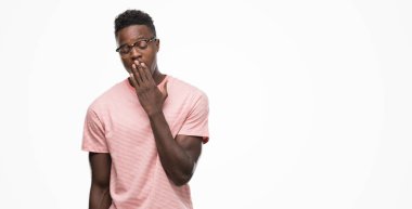 Pembe t-shirt giyen genç Afro-Amerikan adam el ağzıyla kapsayan yorgun esneme sıkılmış. Restless ve uyku hali.