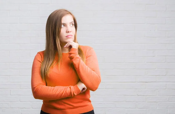 Mujer Adulta Joven Sobre Pared Ladrillo Blanco Cara Seria Pensando —  Fotos de Stock