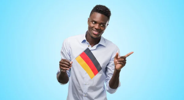 Joven Hombre Afroamericano Sosteniendo Bandera Alemana Muy Feliz Señalando Con —  Fotos de Stock