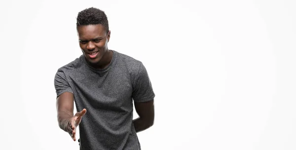 Νεαρός Αφρικανική Αμερικανική Άνθρωπος Που Φορώντας Γκρι Shirt Χαμογελώντας Προσφέροντας — Φωτογραφία Αρχείου