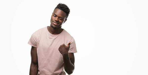 Young african american man pointing with hand and finger up with happy face smiling
