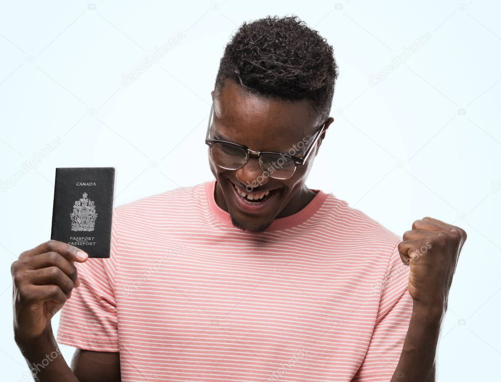 Young african american man holding canadian passport screaming proud and celebrating victory and success very excited, cheering emotion