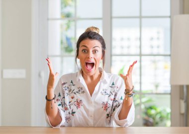 Genç kadın, evde geçirilen silahlarla çılgın ve başarı için hayran kutluyor ve heyecanlı çığlık gözleri açık. Kazanan kavramı