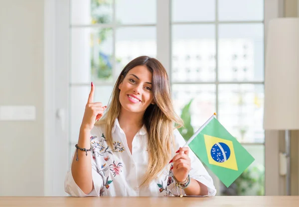 Mujer Joven Casa Sosteniendo Bandera Brasil Sorprendida Con Una Idea —  Fotos de Stock
