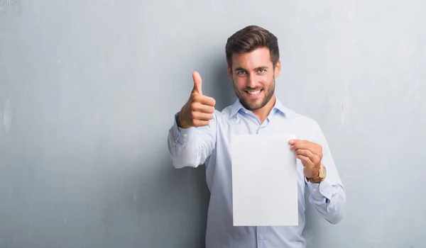 Schöner Junger Mann Über Grauer Grunge Wand Mit Leerem Papierbogen — Stockfoto