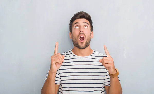 Guapo Joven Sobre Gris Pared Grunge Usando Camiseta Azul Marino — Foto de Stock