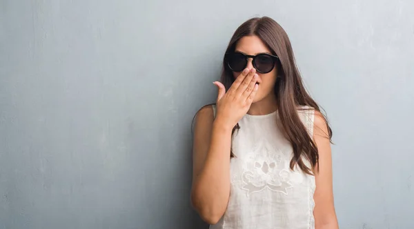 Junge Brünette Frau Über Grunge Grauer Wand Mit Modischer Sonnenbrille — Stockfoto