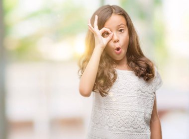 Esmer Latin kız ok jest yapıyor sürpriz yüz, göz parmaklarının arasından seyir ile şok. İmansız ifade.