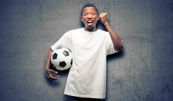 アフリカ黒人持株サッカー ボール大成功 エネルギーおよび肯定的な感情を表現する幸せと興奮の祝う勝利 新しい仕事の喜びを祝う — ストック写真