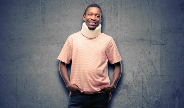 Injured african black man wearing neck brace confident and happy with a big natural smile laughing