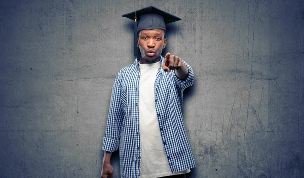 Young african graduate student black man pointing to the front with finger