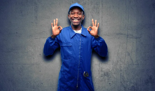 African black plumber man doing ok sign gesture with both hands expressing meditation and relaxation