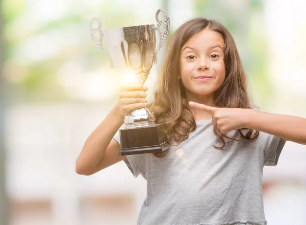 Morena Chica Hispana Sosteniendo Trofeo Muy Feliz Señalando Con Mano —  Fotos de Stock