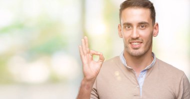 Parmak, mükemmel sembolü ile ok işareti yapan yakışıklı genç erkek