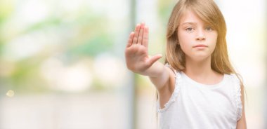 Genç Sarışın toddler açık eliyle dur işareti ile ciddi ve kendine güvenen ifade, savunma hareketi yapıyor