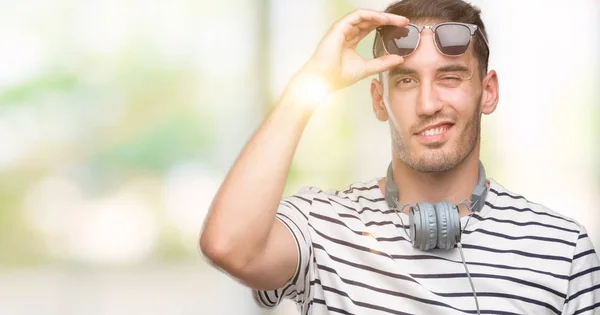 Όμορφος Νεαρός Άνδρας Φορώντας Ακουστικά Winking Κοιτάζοντας Την Κάμερα Σέξι — Φωτογραφία Αρχείου