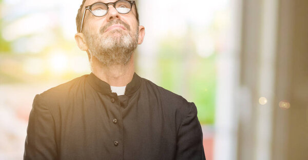 Priest religion man thinking and looking up expressing doubt and wonder