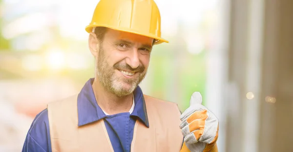 シニア エンジニアの男 建設労働者を広く示す笑みを浮かべて親指カメラのような式および承認するジェスチャを — ストック写真