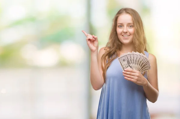 Unga Blonda Kvinnan Håller Dollar Mycket Glad Pekar Med Hand — Stockfoto