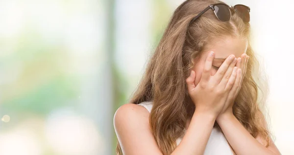 若いブロンドの女性は泣きながら手で顔を覆っている悲しそうな表情でサングラスをかけています うつ病の概念 — ストック写真