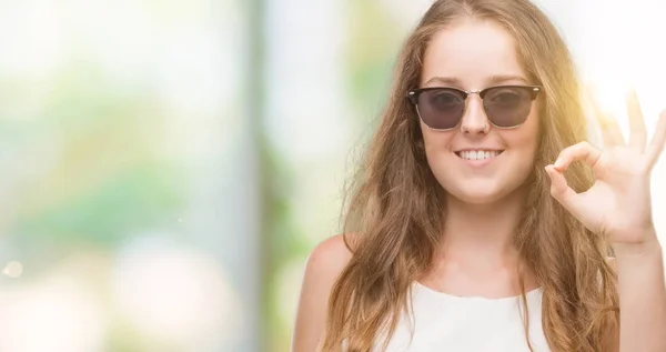 Junge Blonde Frau Mit Sonnenbrille Lächelt Positiv Und Tut Zeichen — Stockfoto