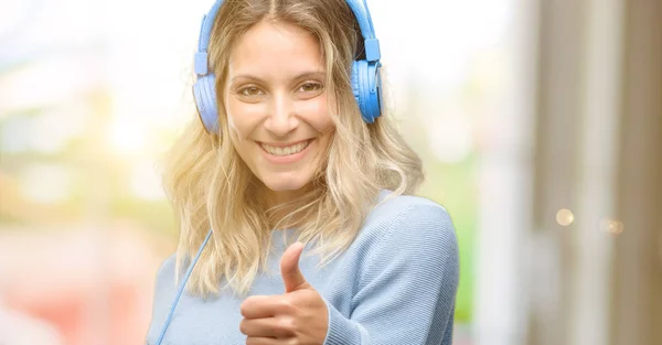 Young Beautiful Woman Listening Music Smiling Broadly Showing Thumbs Gesture — Stock Photo, Image