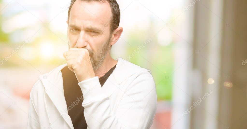 Middle age man wearing sportswear sick and coughing, suffering asthma or bronchitis, medicine concept
