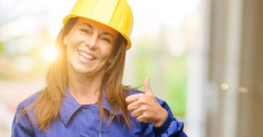 Jest kamera, gibi ifade ve onay için genel olarak gösterilen gülümseyen mühendis inşaat işçisi kadın Yaşasın