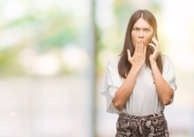 Hata için el utanç ile şok ile Smartphone kapak ağzı kullanarak genç güzel İspanyol ifade korku korkuyor sessizlik içinde gizli kavramı