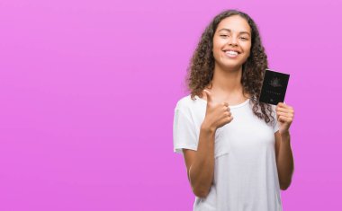 Ok işareti, başparmak ile parmak, mükemmel işareti yapıyor kocaman bir gülümseme ile Avustralya pasaportu mutlu tutan genç İspanyol kadın