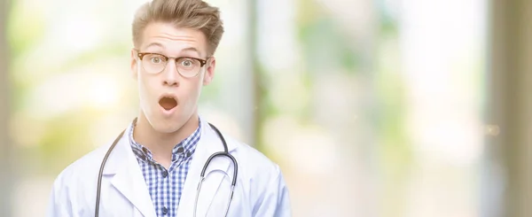 Young Handsome Blond Doctor Scared Shock Surprise Face Afraid Excited — Stock Photo, Image