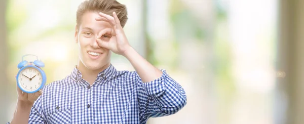 Junge Hübsche Blonde Mann Hält Wecker Mit Glücklichem Gesicht Lächelnd — Stockfoto