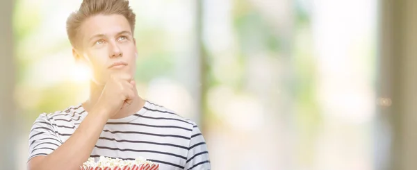 Ung Snygg Blond Man Äta Popcorn Allvarligt Ansikte Funderar Frågan — Stockfoto