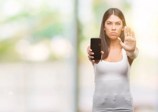 Jovem Bela Hispânica Mostrando Smartphone Com Mão Aberta Fazendo Sinal — Fotografia de Stock