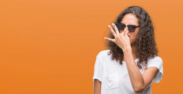 Young Hispanic Woman Wearing Sunglasses Smelling Something Stinky Disgusting Intolerable — Stock Photo, Image