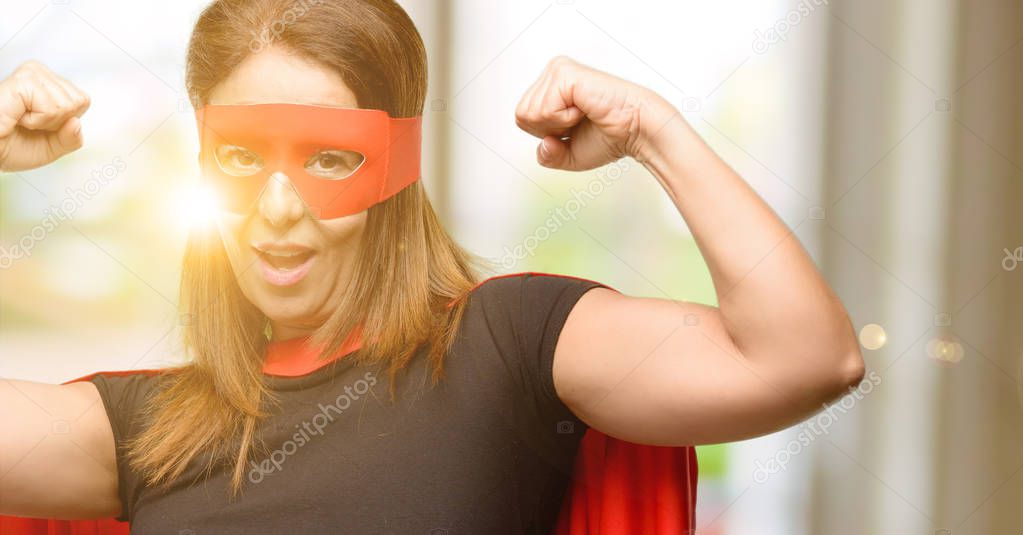 Middle age super hero woman wearing red mask and cape happy and excited celebrating victory expressing big success, power, energy and positive emotions. Celebrates new job joyful