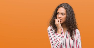 Stresli ve gergin elle çivi ısırma ağzına arayan güzel genç İspanyol kadın. Anksiyete sorunu.