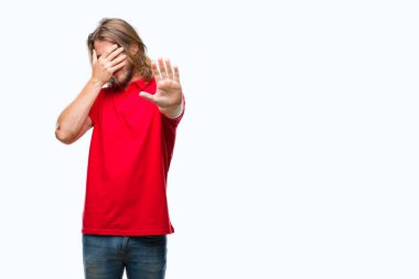 Üzerinde uzun saçlı yakışıklı delikanlı izole elleriyle gözlerini kapsayan arka plan ve stop jest ile acı ve korku ifadesi. Utandım ve negatif kavramı.