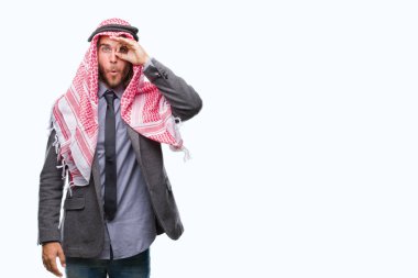 Sürpriz yüz, göz parmaklarının arasından seyir ile uzun saçlı keffiyeh ok jest yapıyor izole arka plan üzerinde giyen genç yakışıklı Arap adam şok. İmansız ifade.