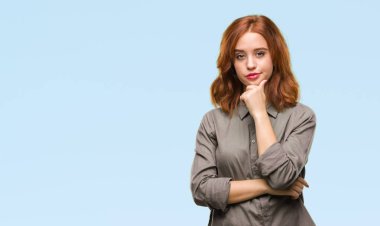 Genç güzel kadın yüzünden izole arka plan emin çapraz kollar ve çeneme kaldırdı el ile gülümseme ile kameraya bakıyor. Pozitif düşünce.