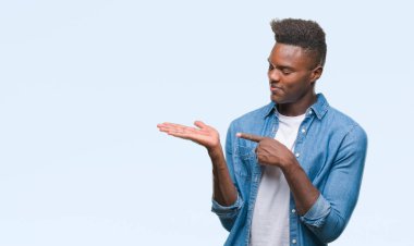 Genç Afro-Amerikan adam üzerinden hayran ve el ile sunulması ve parmak ile işaret ederken kameraya gülümseyen izole arka plan.