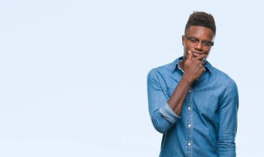 Afrikalı-Amerikalı genç emin çapraz kollar ve çeneme kaldırdı el ile gülümseme ile kameraya bakarak izole arka plan üzerinde. Pozitif düşünce.