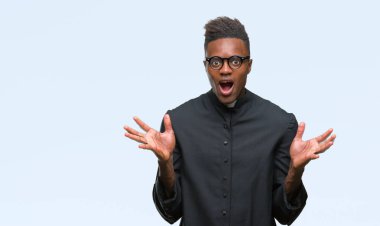 Genç Afrikalı-Amerikalı adam deli kutluyor izole arka plan üzerinde rahip ve silah ile başarı için yükseltilmiş ve açık gözleri heyecanlı çığlık hayrete düşürdü. Kazanan kavramı