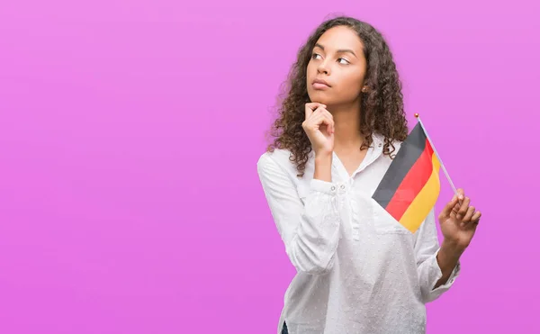 Mladá Žena Hispánský Drží Vlajka Německo Vážná Tvář Přemýšlet Otázku — Stock fotografie