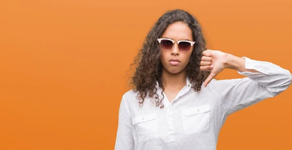 Młodych Hiszpanin Kobieta Nosi Okulary Gniewną Twarz Wyświetlono Niechęć Kciuk — Zdjęcie stockowe
