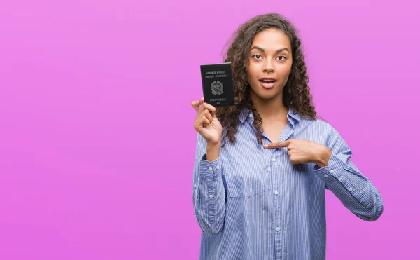 Jovem Hispânica Segurando Passaporte Itália Com Rosto Surpresa Apontando Dedo — Fotografia de Stock